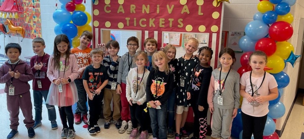 MHE students standing next to a carnival ticket booth.